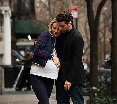 Will and a pregnant Abby stand, leaning; arms wrapped each other in the streets of London.