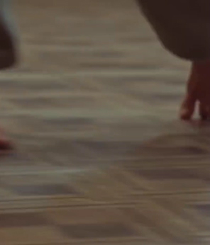 Susie spins around and crouches in dance; throwing her head back when she lands.