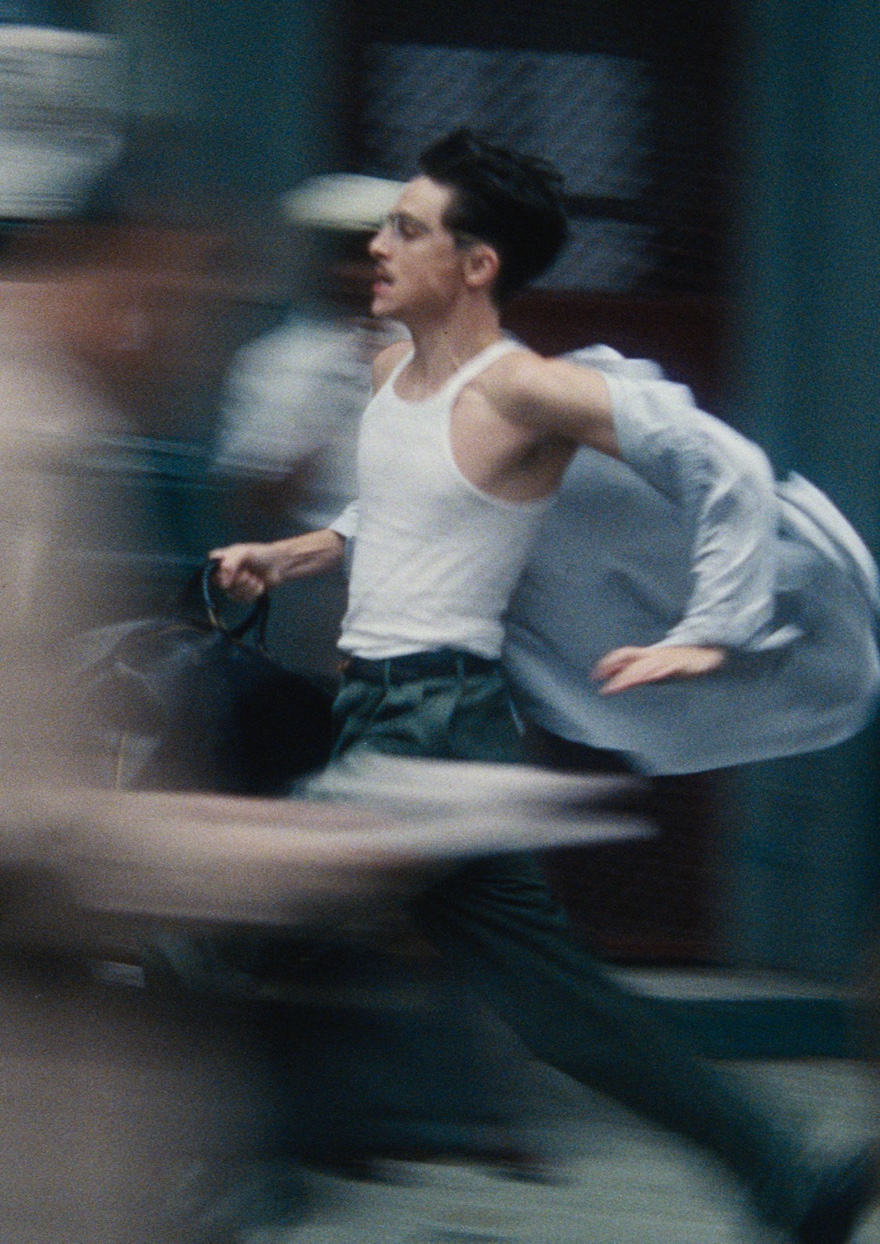 A man running through the streets holding a suitcase.
