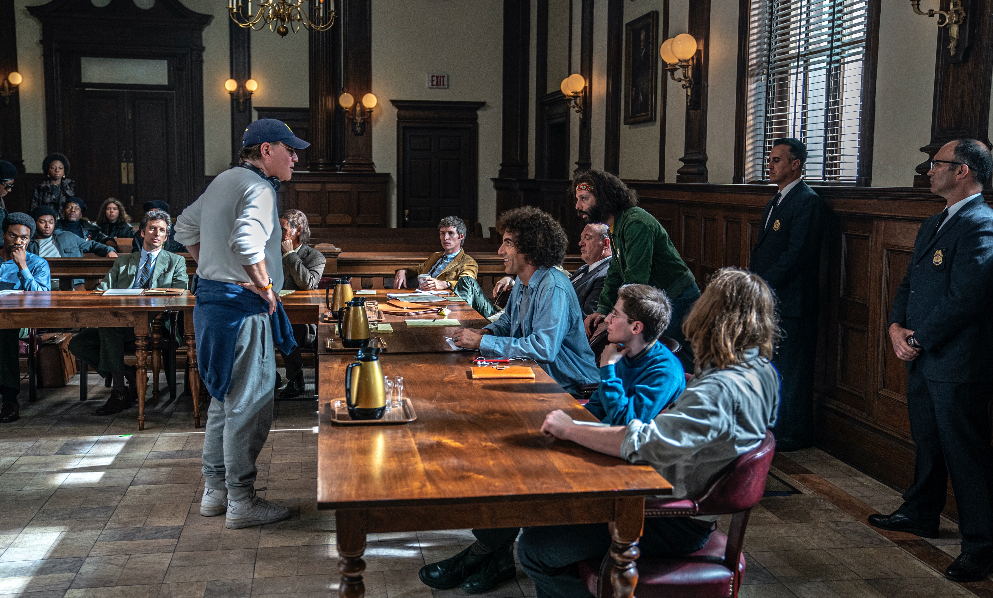 Aaron Sorkin stands across from his cast as he directs them in a courtroom scene in The Trial of the Chicago 7. Watch as he compares himself to an adorable animal . . .